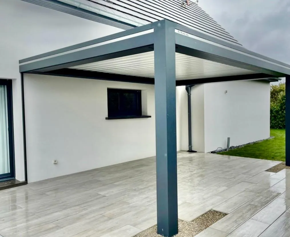 Pergola bioclimatique à lames orientables en aluminium anthracite sur terrasse carrelée